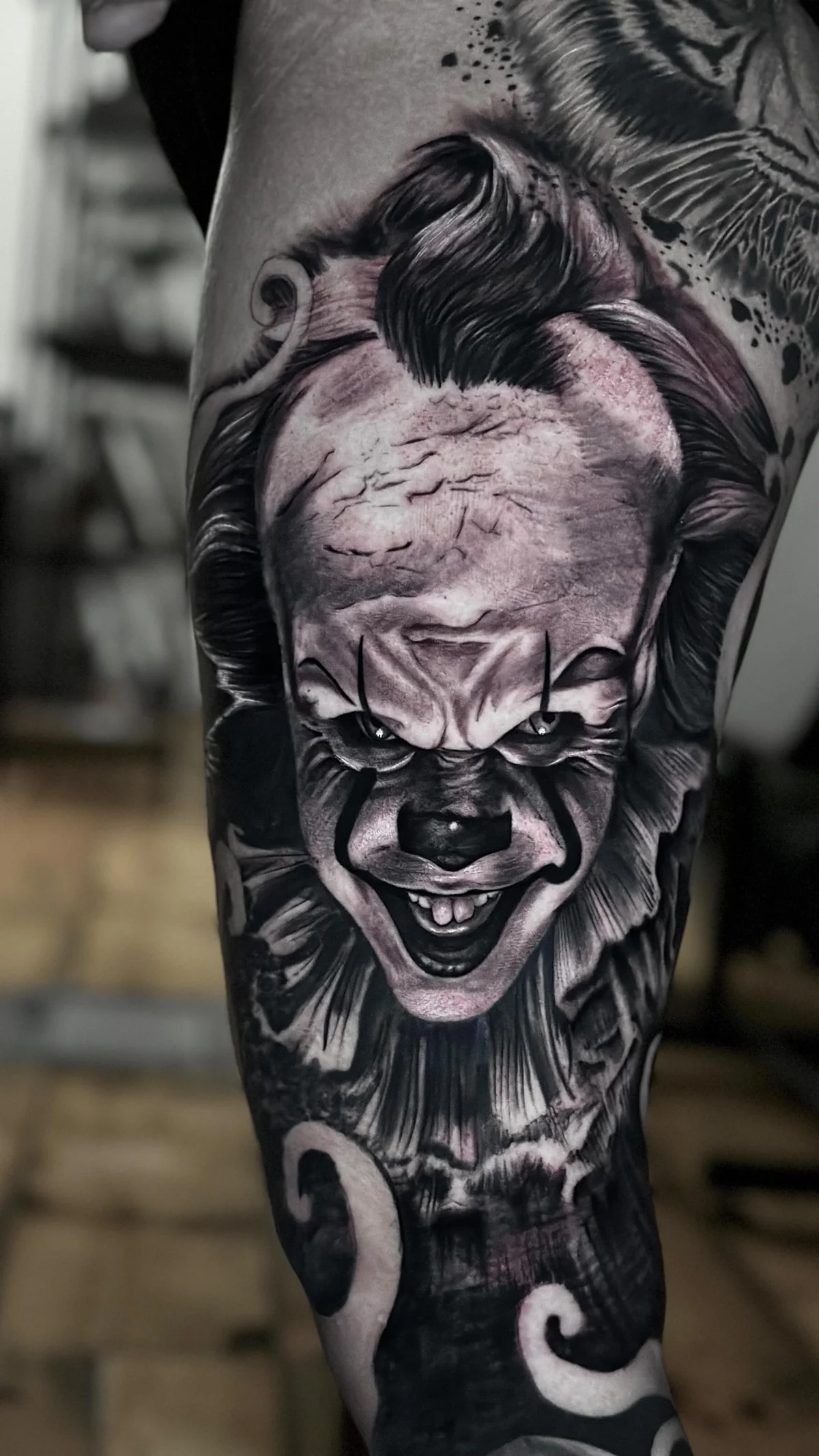 a Pennywise clown portrait on a healed leg sleeve, black and grey realism tattoo by Lucas Zatti, Temple Bar Dublin